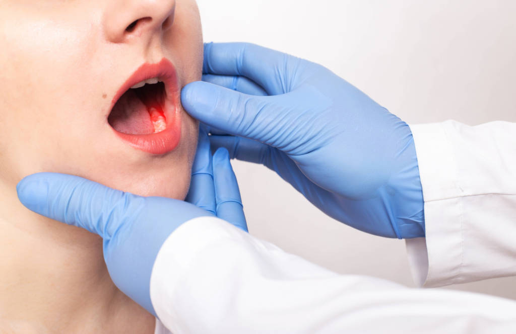 Tannlege undersøker munnen til ung pasient