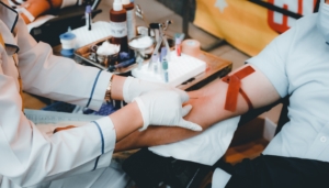 Bioingeniør tar blodprøve i armen på pasient