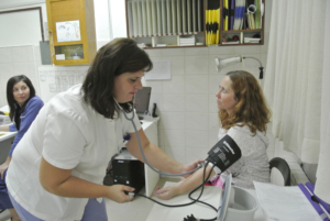 Sykepleier måler blodtrykk på en pasient