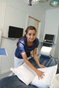Kvinnelig tannlege legger puter i tannlegestol