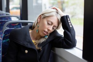 En kvinne som sover på bussen