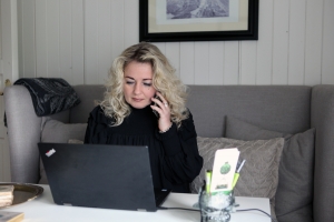 Lillann Wermskog i telefonen foran laptop