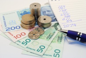 Norske sedler og mynter, notatbok med tall og en penn