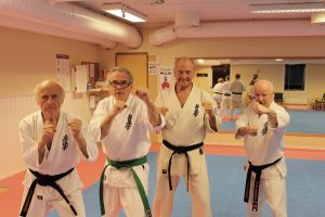 Fire eldre menn i karatedrakter