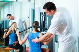 Fysioterapeut veileder pasient som trener