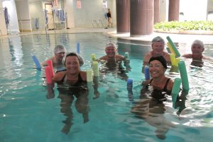 6 personer trener i et basseng med fargerike pøller
