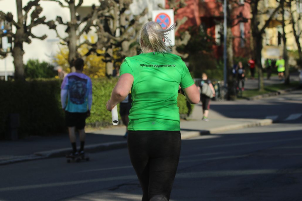 Kvinne løper med grønn t-trøye
