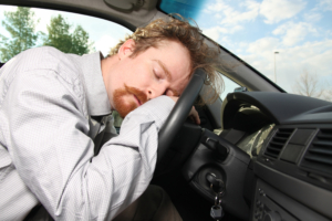 Mann sover på rattet i en bil