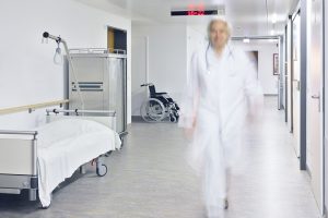 Lege i full fart gjennom sykehuskorridor