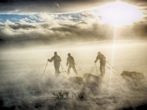 Tre mennesker på ski i tåke