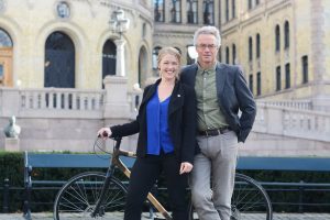 Une Bastholm og Rasmus Hansson med en sykkel foran Stortinget