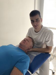 Fysioteraput jobber med nakken til mann på benken