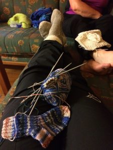 To par kvinnebein i sofa med strikketøy i fanget