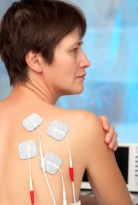Kvinne med TENS-elektroder på skulderbladet