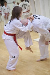 Dame som bruker taekwondo-teknikk på en mann