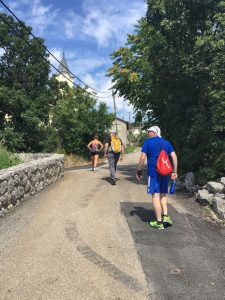 Tre personer i turtøy på vei opp bakker i en fjelllandsby