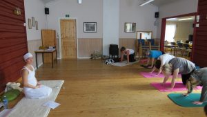 Yogainstruktør foran elever i yogaposisjoner