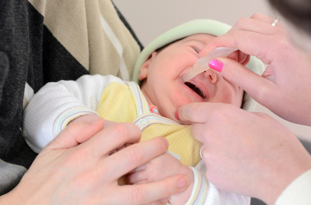 Baby får medisin via munnen
