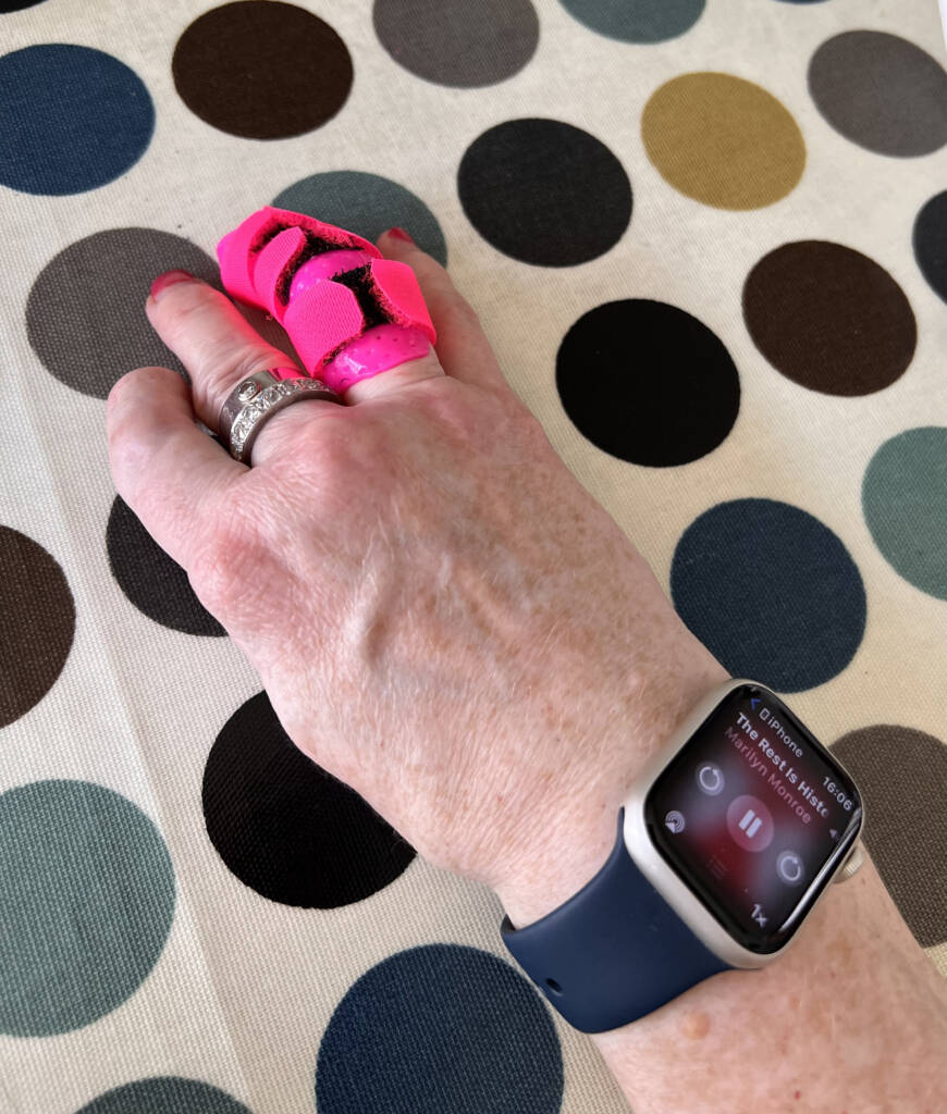 Hånd med en Barbie-rosa fingerskinne