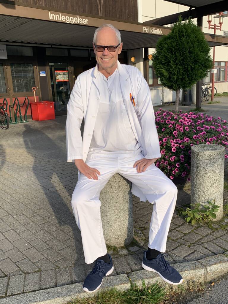 Revmatolog og professor Glenn Haugeberg sitter utenfor inngangen til Sørlandet sykehus.